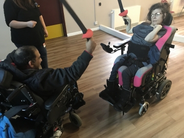 Two wheelchair users learning to fence